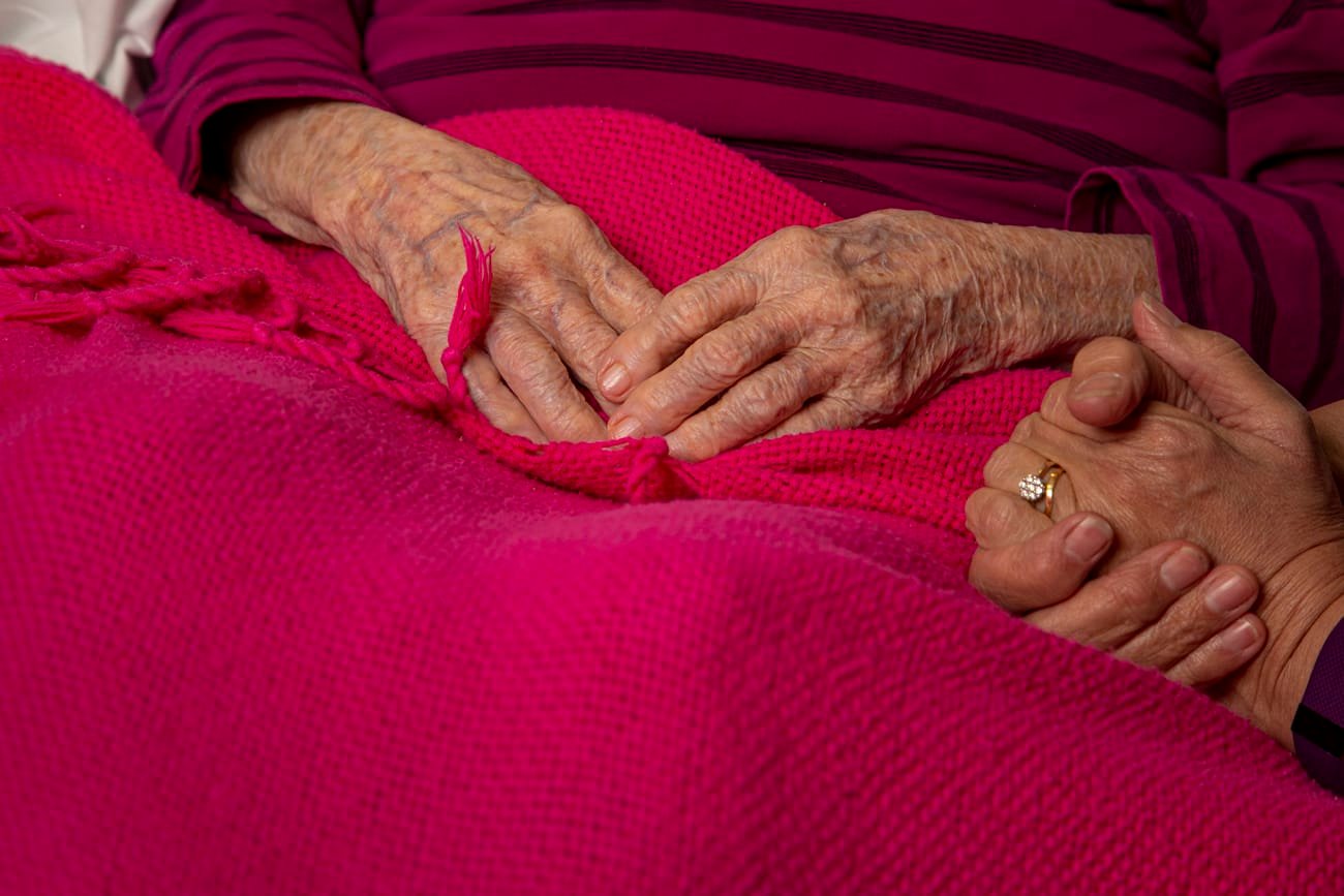 Detail business branding photo of hands resting in lap for community organisation