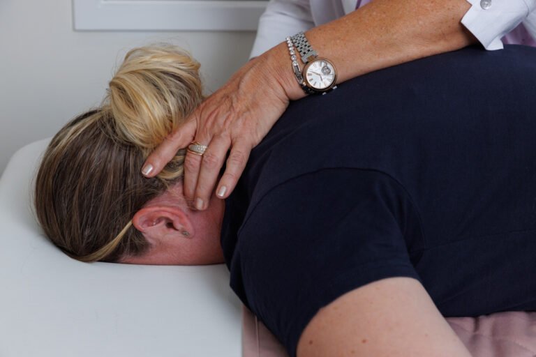 Close up of fingers of spinal flow practitioner on spine of client for wellness branding photo