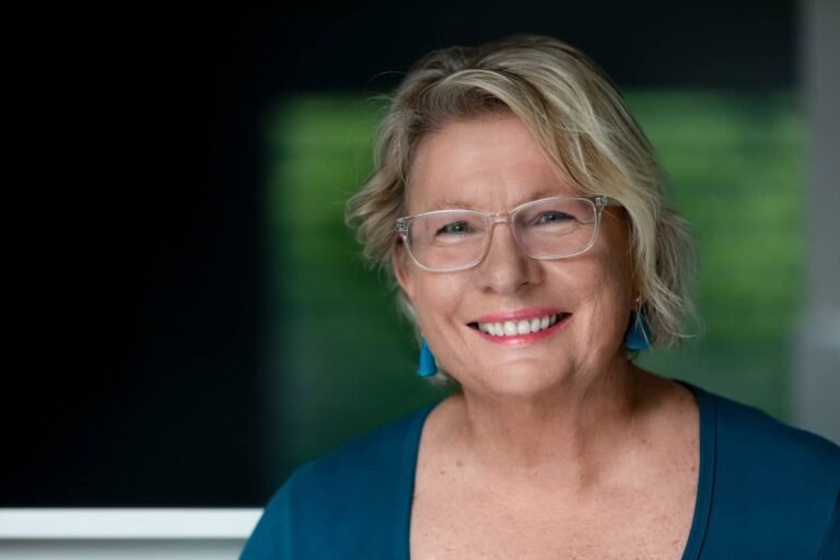 Wellness branding and personal branding headshot of female life coach smiling at camera