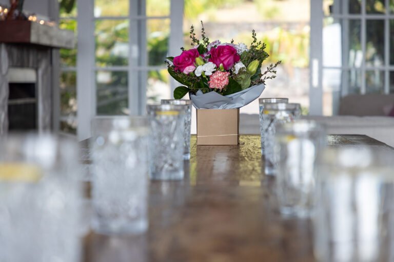 Detailed wellness branding photo of table with bouquet of flowers and glasses