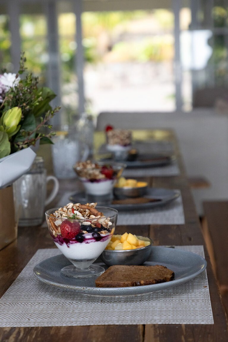 Table setting of healthy breakfast of fruit, muesli, coconut yogurt and vegan banana bread for wellness branding photo