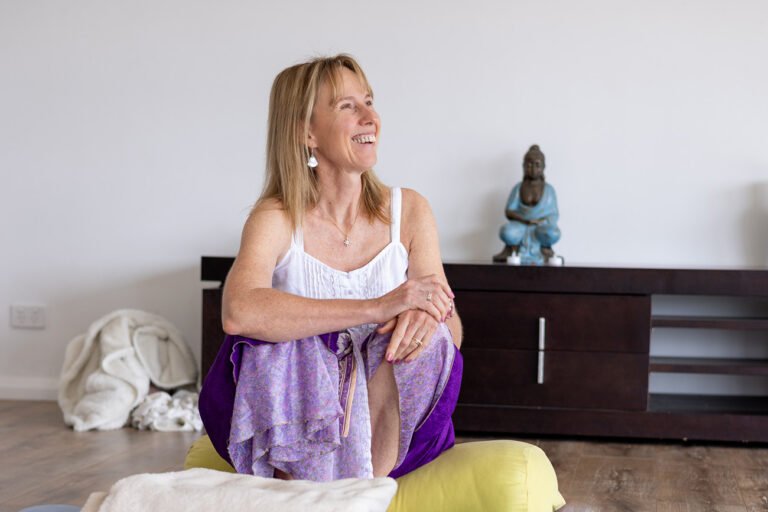 Female wellness practitioner sitting and looking upwards in conversation with someone else out of shot for wellness and business branding