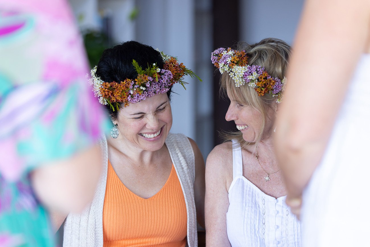 Shoot through of two ladies giggling together at women's retreat for wellness branding photo
