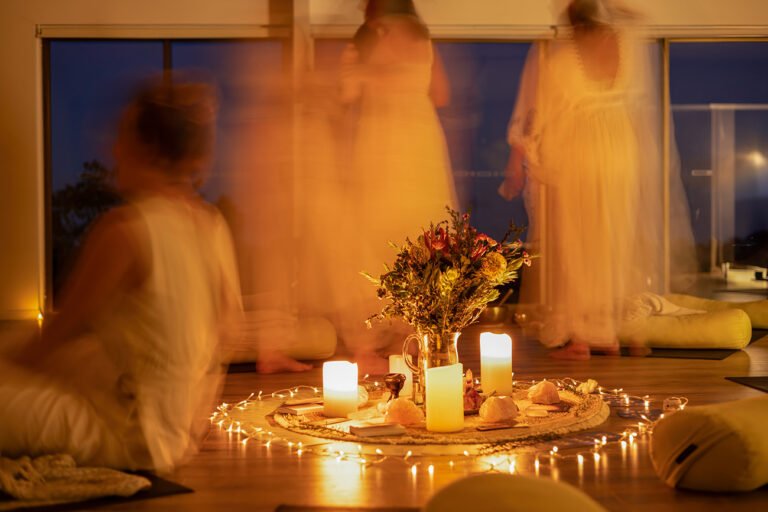 Arty wellness branding photos with floral & candle centrepiece and blurred motion of women around it